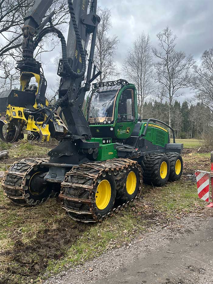 Traktor med släp fullt med stockar